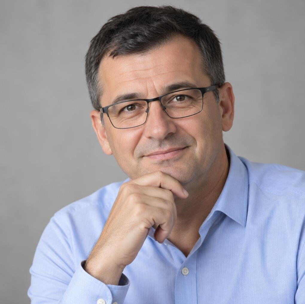 Man with glasses and a thoughtful smile in a shirt